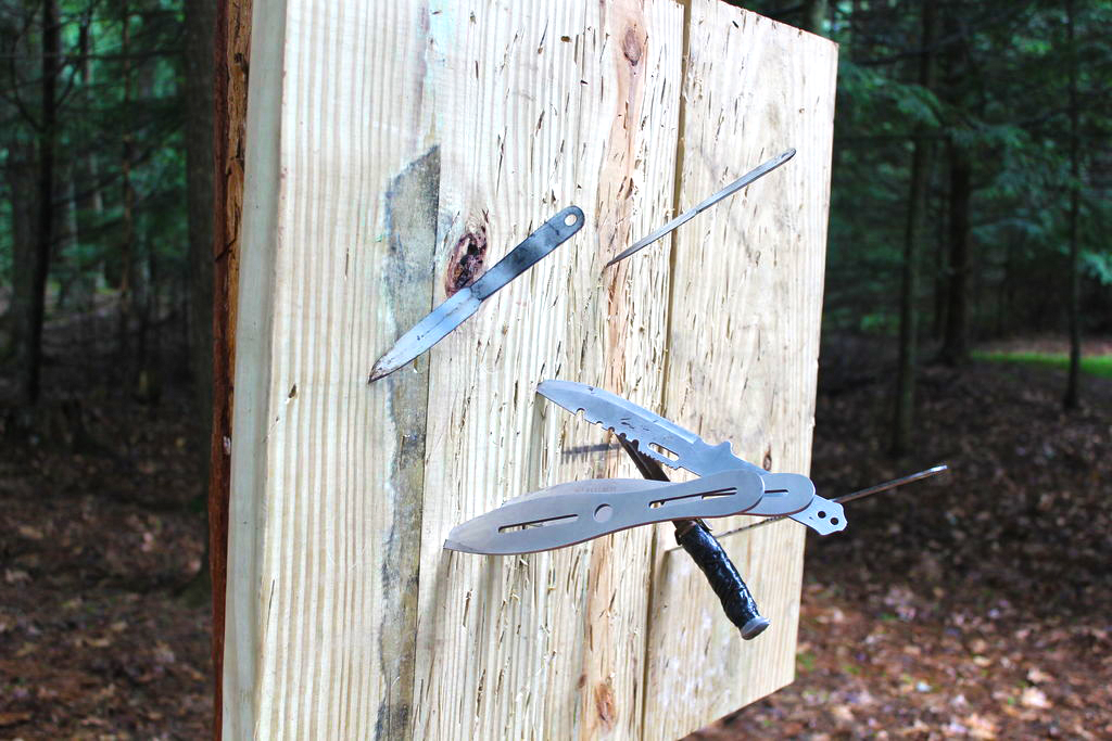 Wooden throwing target with bunch of throwing knives